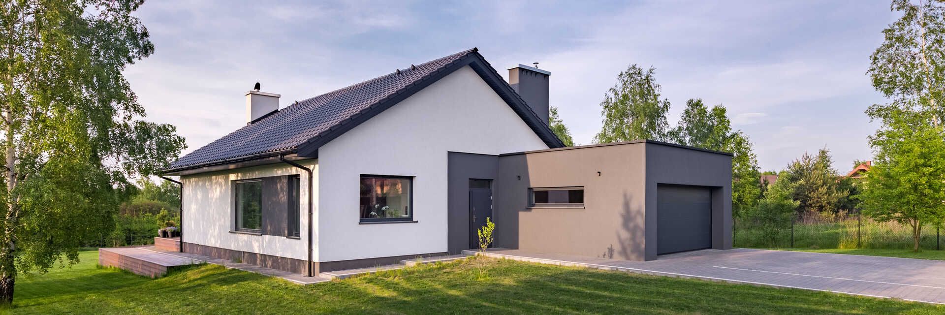 Modernes Haus mit Garage und Solarpanelen auf dem Dach