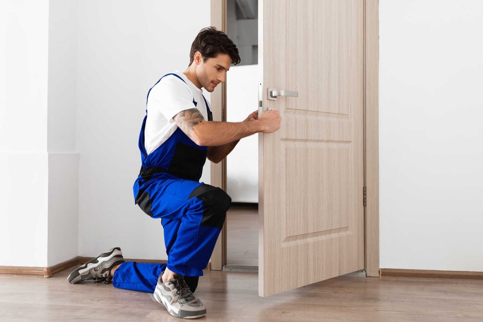 Ein Mann in Latzhose repariert eine Tür, um die Sicherheit des Hauses zu gewährleisten